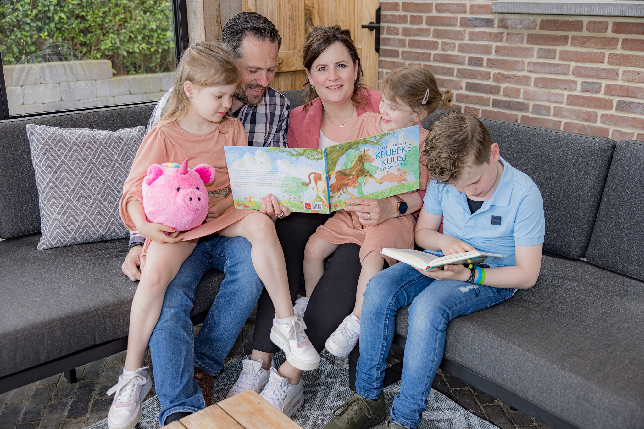 Ellen Schmitz met haar man en kinderen lezen samen een boekje
